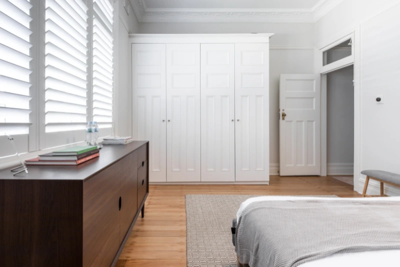 reforma integral en Vallcarca , distrito de Gracia, Barcelona. Reformas Grupo AyM habitación elegante y confortable con armario y detalles en madera