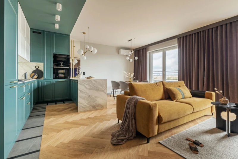 reformas integrales en Ciutat Vella en el Gòtic - cocina muy luminosa y detalle de isla y mesa del comedor y sofá en primer plano