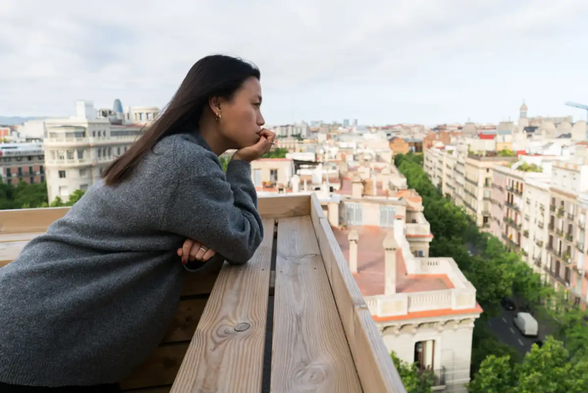 mujer contemplando la ciudad de Barcelona miestra piensa conceptualmente en subvenciones reforma y rehabilitación Barcelona